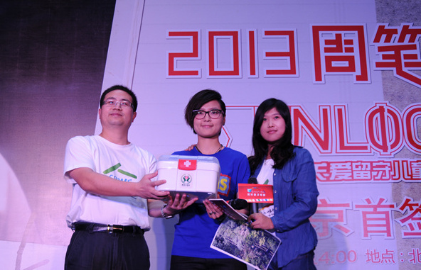 稚愛基金工作人員與周筆暢手捧著小藥箱合影