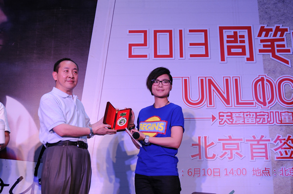 給周筆暢頒發(fā)關(guān)愛留守兒童的榮譽胸章