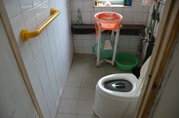 改造后的霍秀如奶奶家的卫生间,安装了“一”型扶手,配备了坐便式马桶座椅.jpg