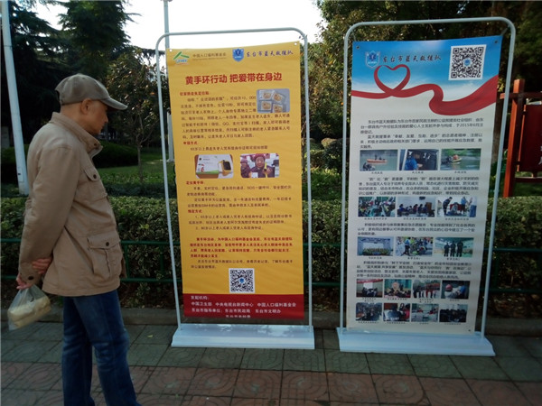 1509335526595947.jpg 老人在活動宣傳展板前駐足.jpg